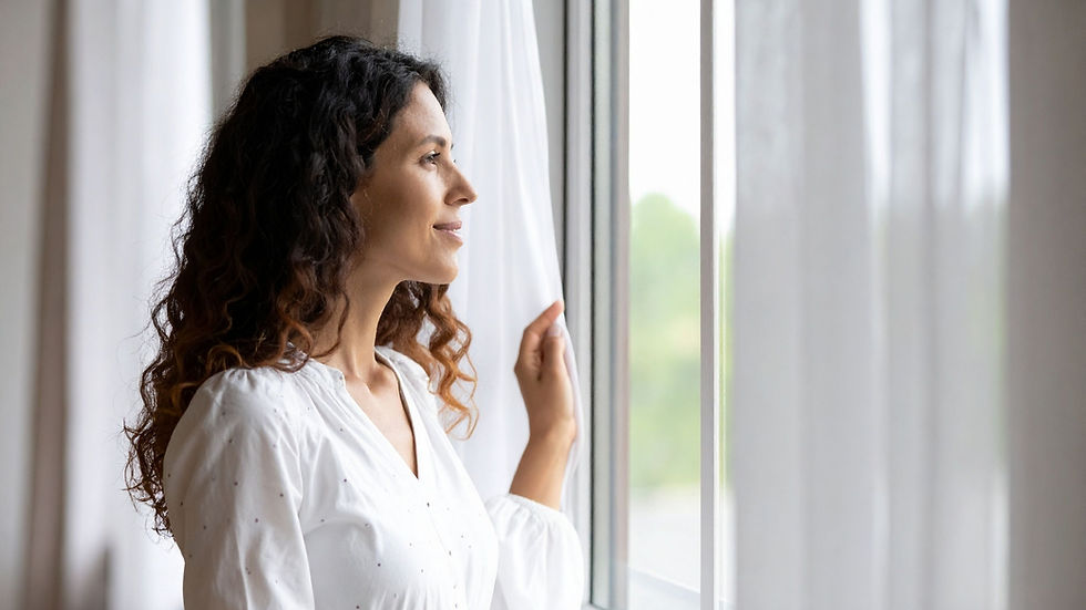 A smiling woman looking out the window.
