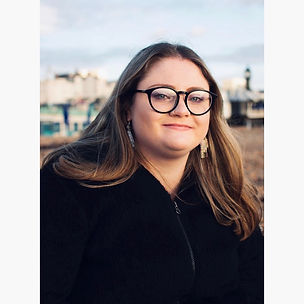 Image shows Jodie with her hair down, wearing glasses and smiling directly at the camera.