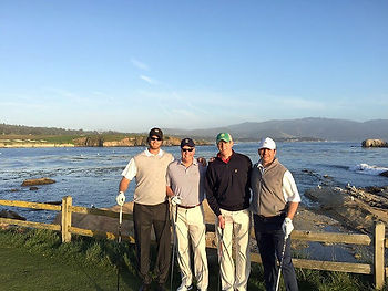 Four guys smiling on golf course