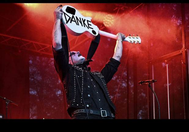 Dennis hält eine Gitarre nach oben auf der "Danke" steht.