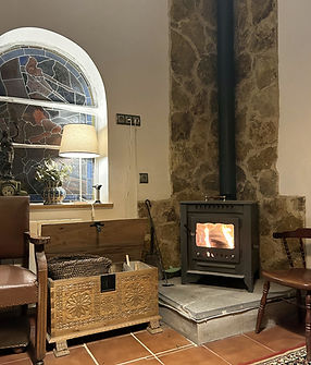 Salón con chimenea de leña y roca natural en Legendarium Casa Rural, Salamón