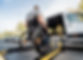 A man in a wheelchair moves to the lift of a specialized vehicle .jpg