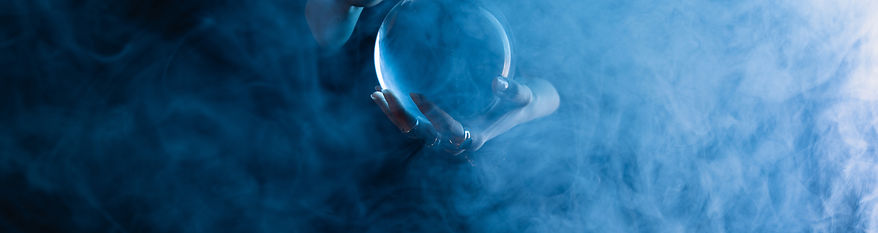 cropped-view-of-witch-holding-crystal-ball-on-dark-2022-12-16-21-32-41-utc.jpg