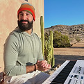 Matt Fetbrandt sits at a keyboard in front of a retreat house in Joshua Tree