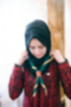 A scout putting on her scarf.