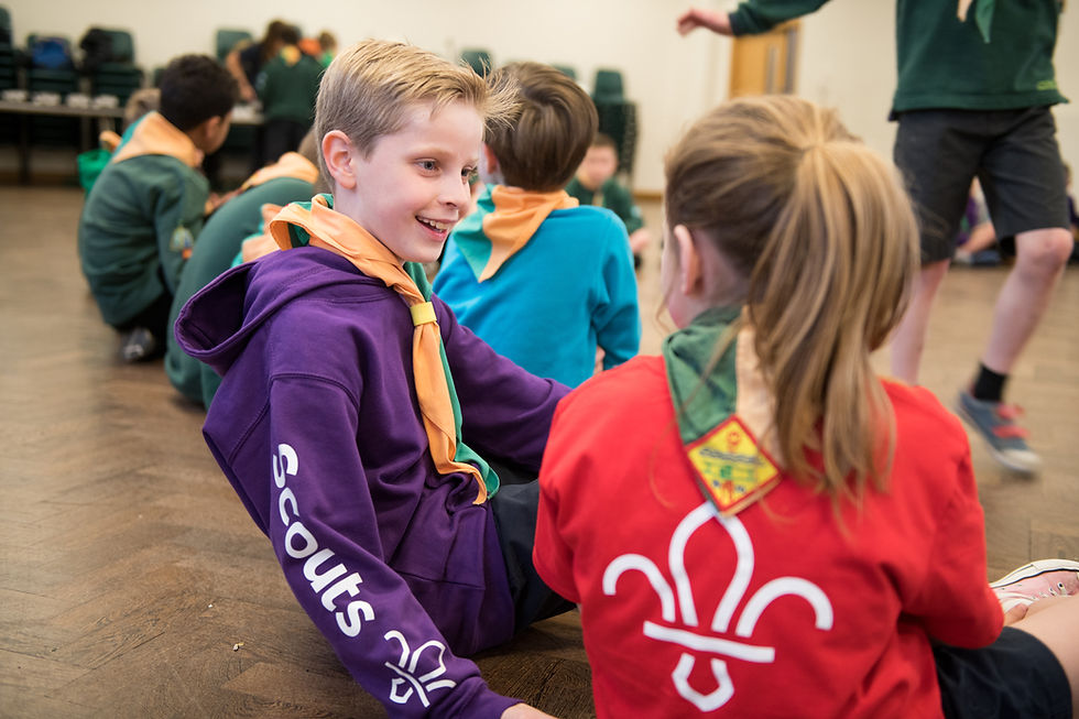 Two cubs chatting in a scout hut.