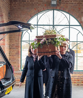 Mourners carrying a coffin into a crematorium_edited.jpg