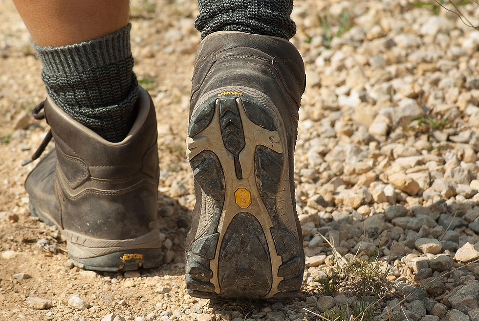 Zwei Füße in Wanderschuhen auf einem Naturweg – Symbol für achtsames Gehen, Wandern in der Natur und kreative Bewegung.