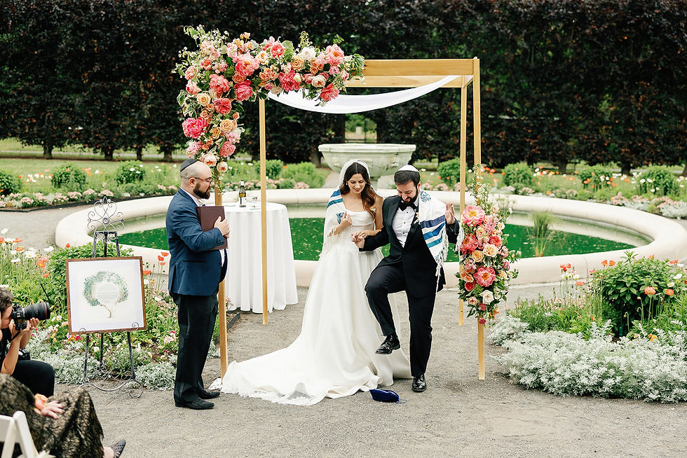 Smashing the glass. Jewish wedding ceremony beneath a floral chuppah in the Italianate Garden at Elm Bank