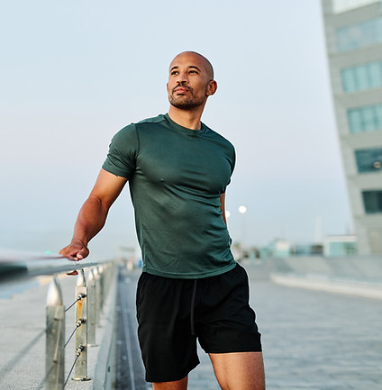 Portrait os a happy bhandsome black man exercising and stretching outdoors.jpg