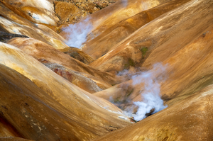 Red rhyolite hills converge together in this geothermal area of Iceland.