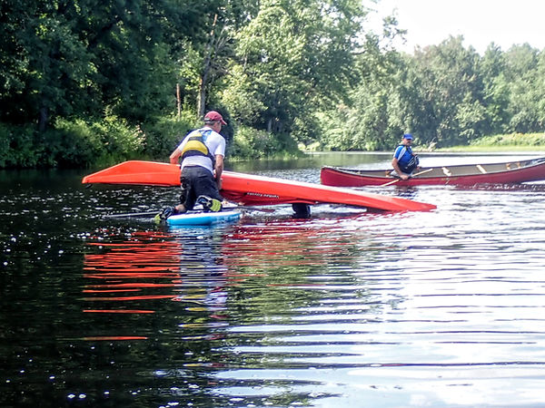 Standup paddlenboarder rescuing a kayaker