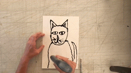 In this gif, an outline of a cat with triangles filling the background is being created by an artist.