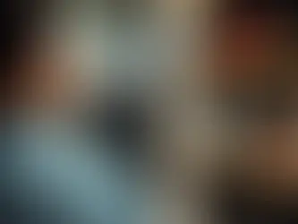 A person holds several $100 bills near a store shelf filled with electronics. The mood suggests anticipation or decision-making.