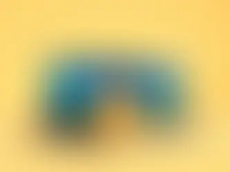 Two laptops with blue-green screens on a yellow background. A yellow card with a black question mark stands in front, creating a curious mood.