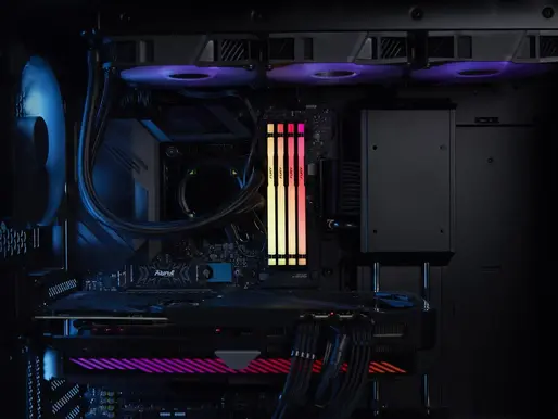 Inside view of a PC with colorful RGB lighting on RAM sticks and cooling fans. Dark interior creates a futuristic and tech-focused mood.