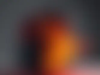 Black computer tower with red fan emits realistic flames on a gray background, creating a fiery, intense mood.