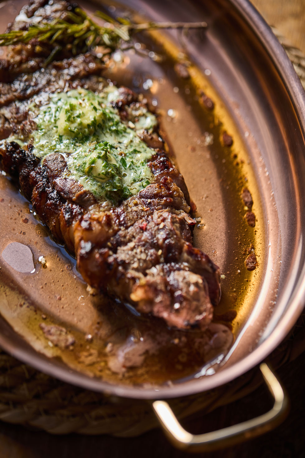Steak with herb butter on a copper plate.