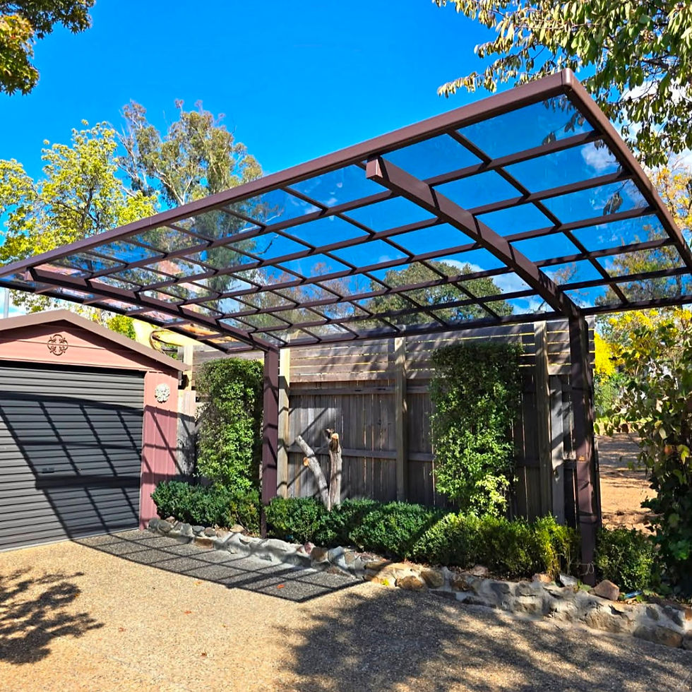 Modern glass and metal carport structure in a driveway