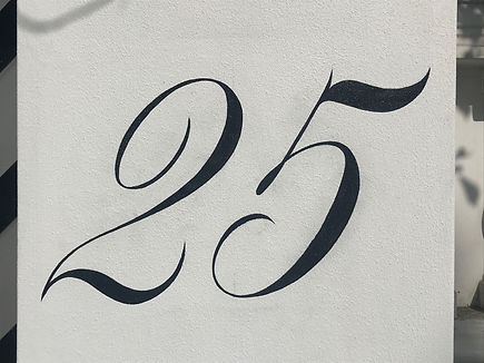 Hand painted 25 house number on column