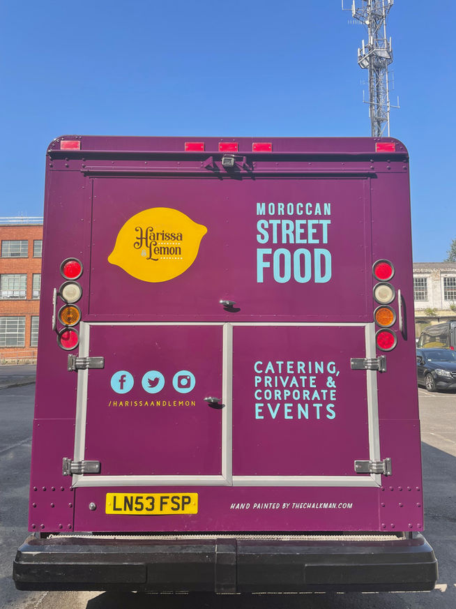 Back doors of a food truck showing the hand painted logo and signage 