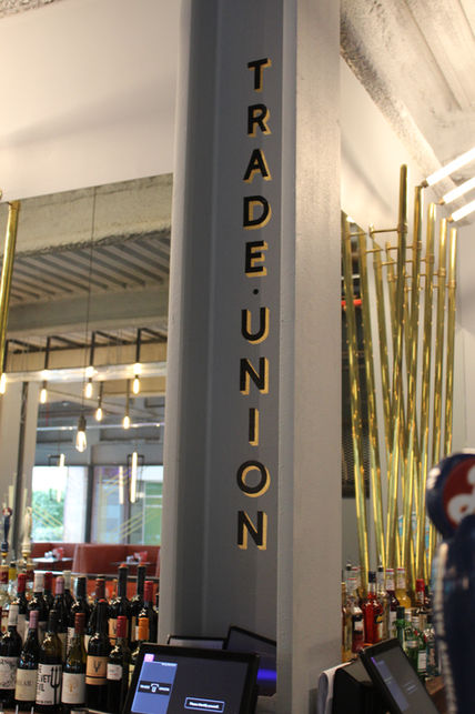 gold leaf and hand painted lettering on steel beam inside restaurant 
