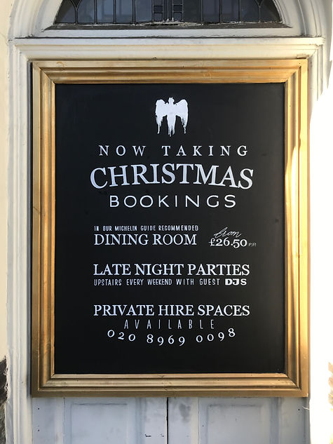 External hand written chalkboard advertising bookings for restaurant