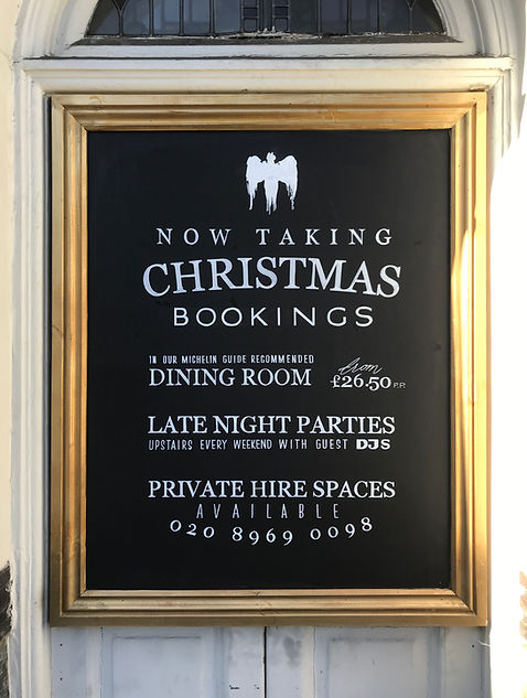 External hand written chalkboard advertising bookings for restaurant