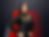 Woman in a black racing suit with logos stands confidently against a red and gray background, hands on hips, projecting determination.