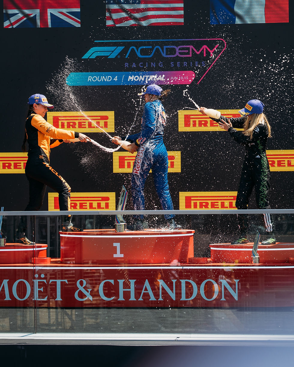 Three race drivers spray champagne on a podium with flags above. Red platforms numbered 1, Pirelli logos, Moët & Chandon text visible.