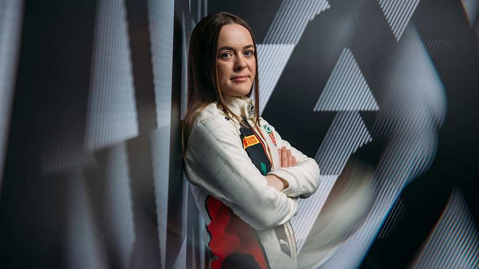 Woman in a racing suit stands confidently with arms crossed, set against a dynamic black and white geometric background.