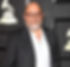 Photo of a smiling man wearing dark suit jacket and white shirt with eyegkasses