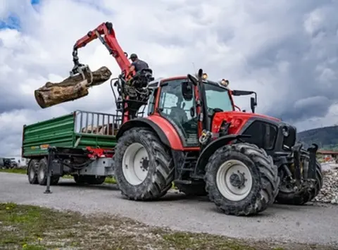 Traktor mit Holzanhänger und Kran
