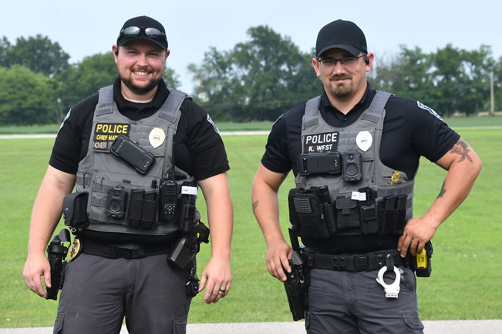 Police Chief Zachary Mathies, left, and Officer Kurtis West direct traffic entering the park.