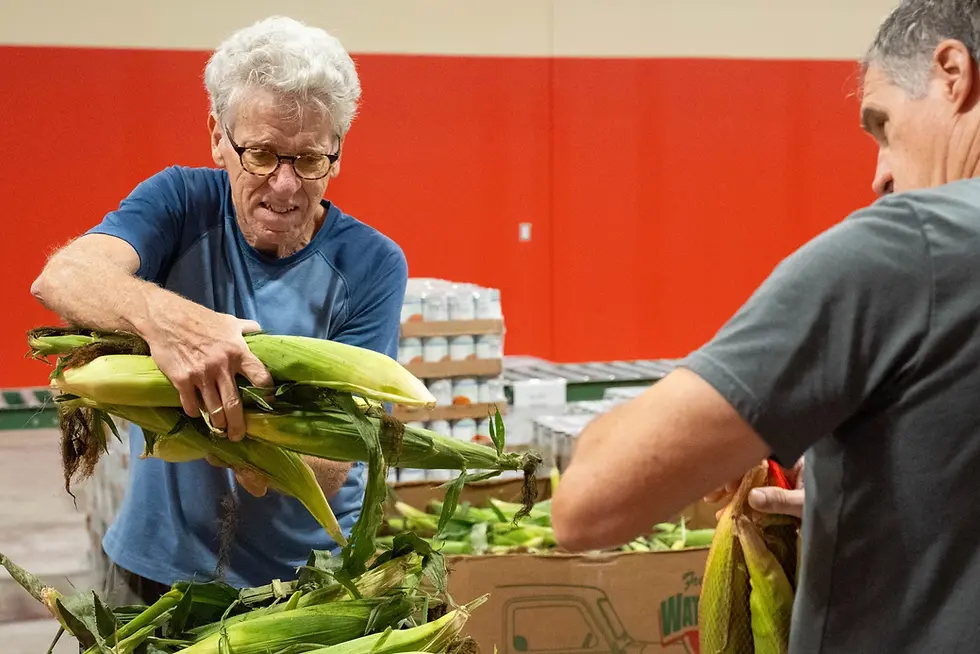 Steve Vossler, left, volunteers at the Harvesters distribution center in Lawrence, Kansas. (Zane Irwin / Kansas News Service)