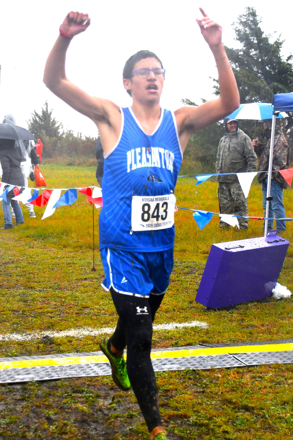 Wet and splattered with mud, Pleasanton's top distance runner Miles Alvarez crosses the finish line at the regional cross county meet at Central Heights on Saturday, October. 25. (Submitted)