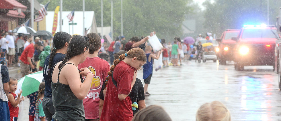 When you can't get any wetter . . . Once they were soaked, kids along the parade route splashed into the street to grab candy.