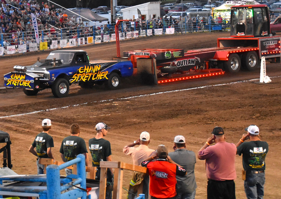 Bystanders cover their ears as "Chain Stretcher" driven by Toby Vanderpool of Indianola, Iowa, places second in the Pro Truck 4x4 class with a pull of just over 298 feet.