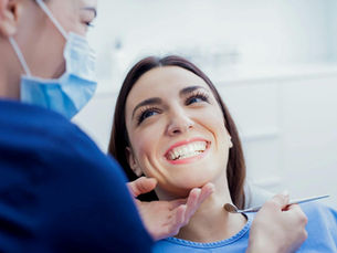 uśmiechnięta kobieta na fotelu dentystycznym