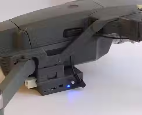 DJI Mavic 3 drone can be seen here sitting idle on a white table with side view where attached sensors for payload release and drop from drone sky hook can be seen
