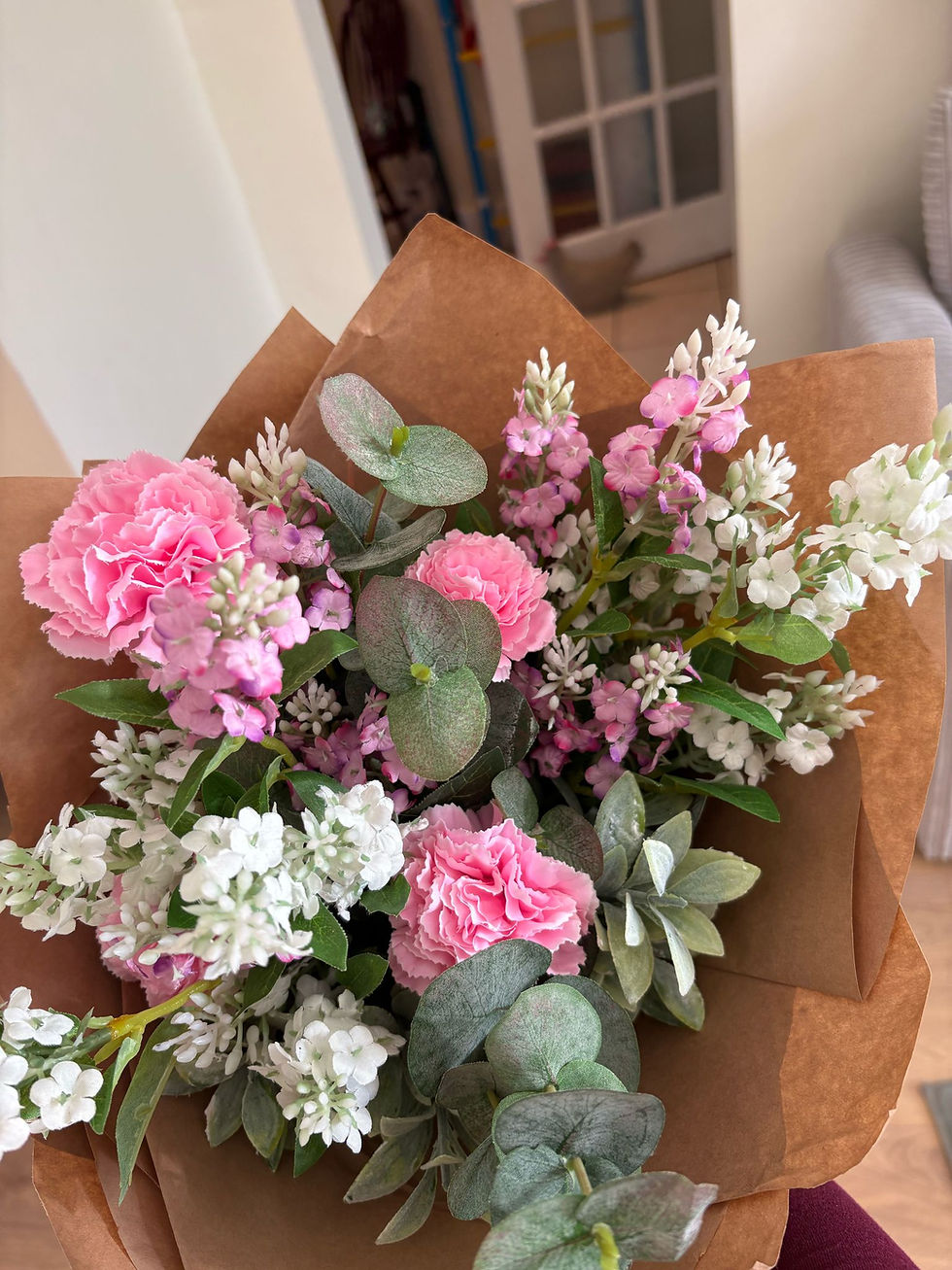 Our artificial carnation bouquet of  handtied flowers wrapped ready to go in brown wrap