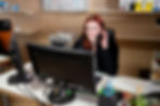 Verwaltungsmitarbeiterin sitzt am PC und telefoniert