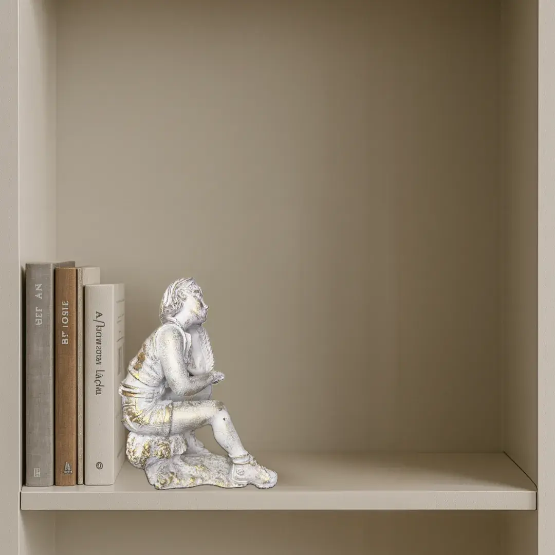Figura decorativa de persona sentada en posición reflexiva con acabado blanco y dorado