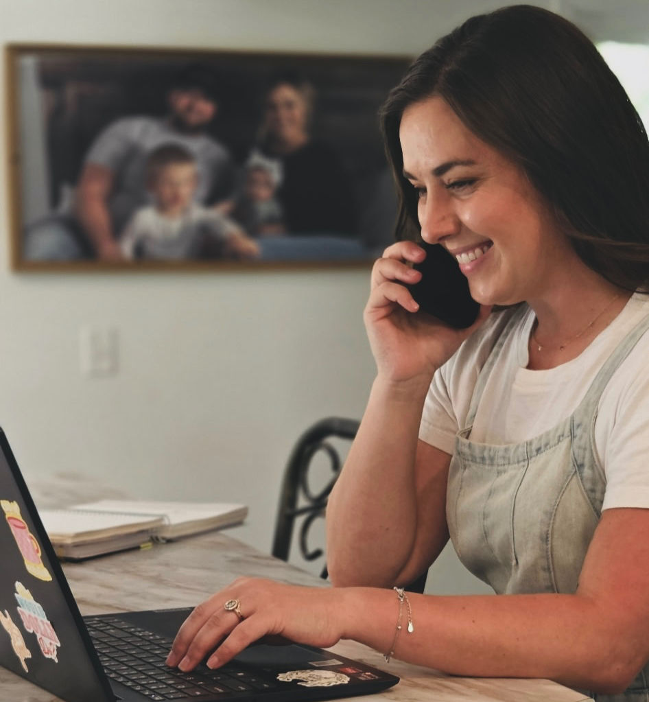 Woman on a troubleshooting call, smiling and typing on a laptop