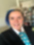 Sara Soto featured in a headshot wearing a Navy suite and white colored shirt with a bold lighter blue polkadot tie