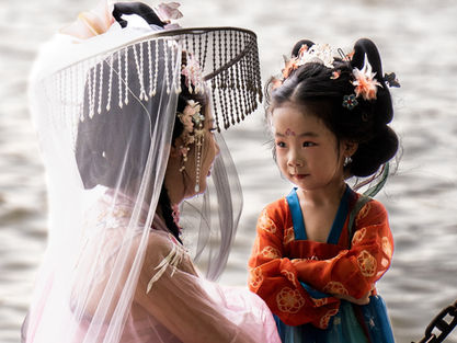 Mulher chinesa com sua filha se olhando às margens do rio West vestidas com roupas tradicionais chinesas