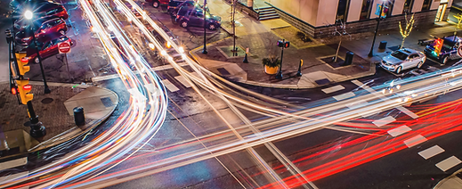 carros trafegando rápidos por um cruzamento movimentado