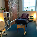 Massage studio at night, lit by cosy lamps.