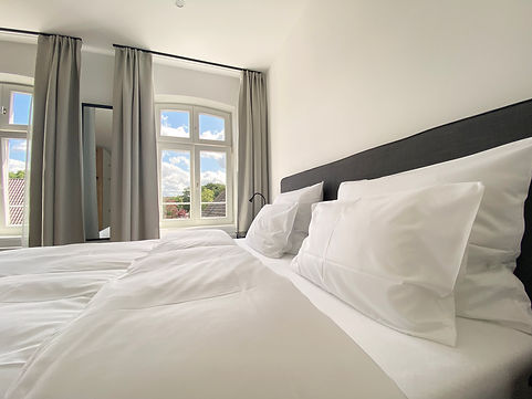 Hotelzimmer Doppelbett sonnigem Fensterausblick