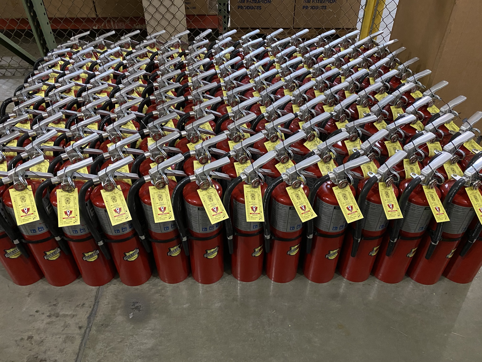 Eye-level view of a technician inspecting a fire extinguisher in a commercial warehouse